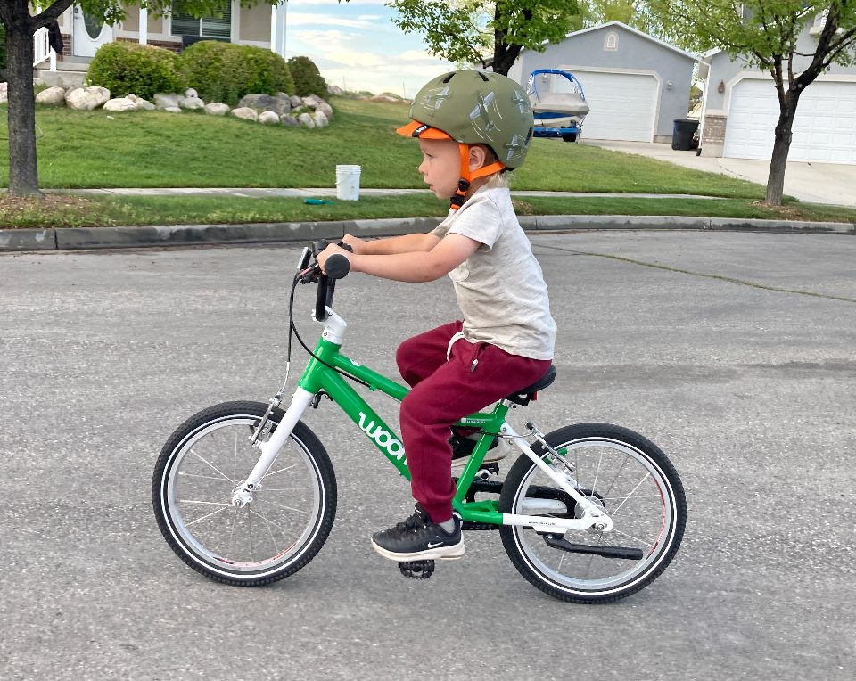 Boy riding bike and wearing Bern Nino kids bike helmet