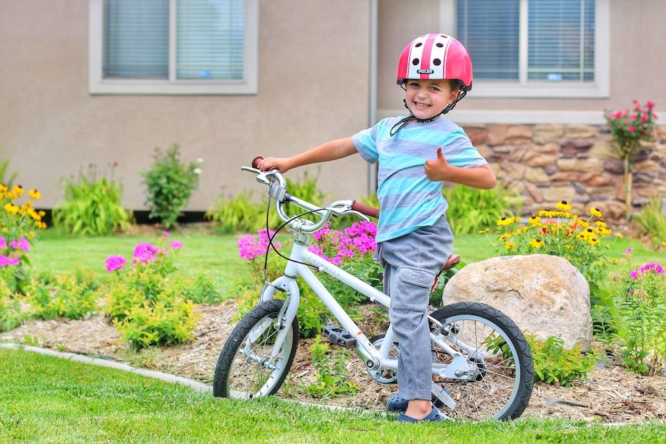 Child giving a big thumbs up while riding his Priority Start 16