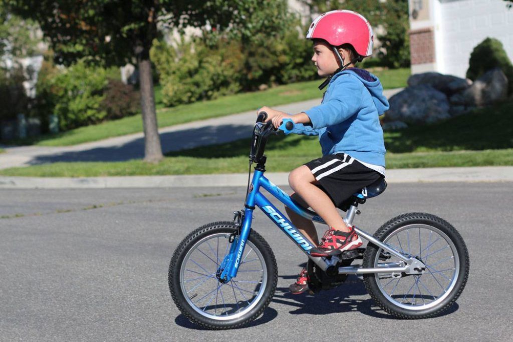 boy riding a blue schwinn smartstart 16 inch bike