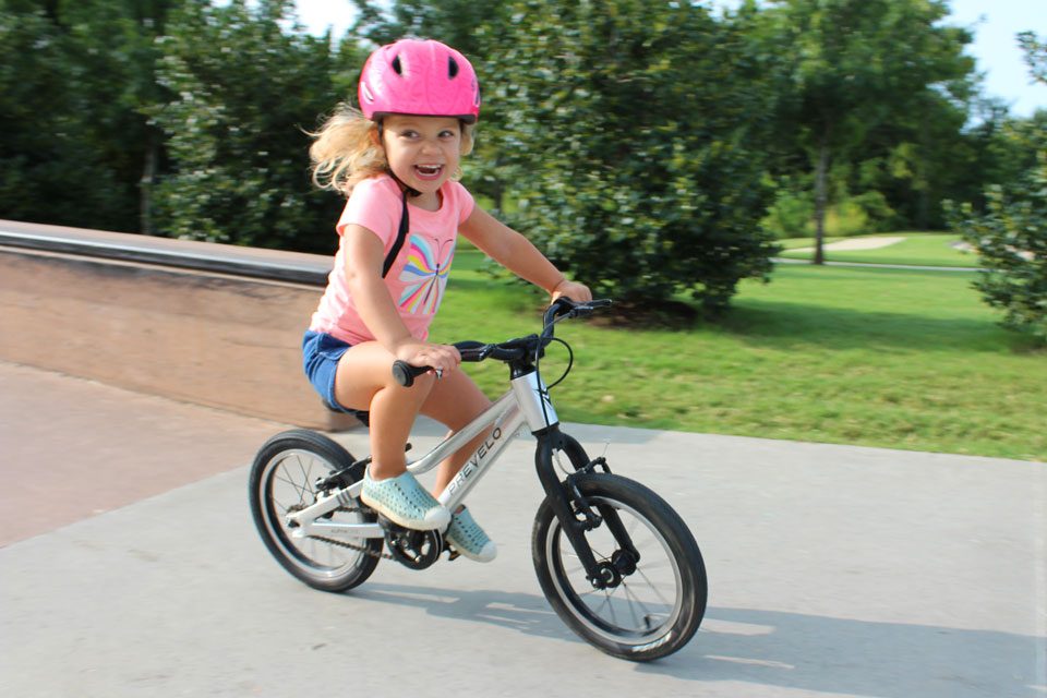 Young girl riding a 14 inch small pedal bike