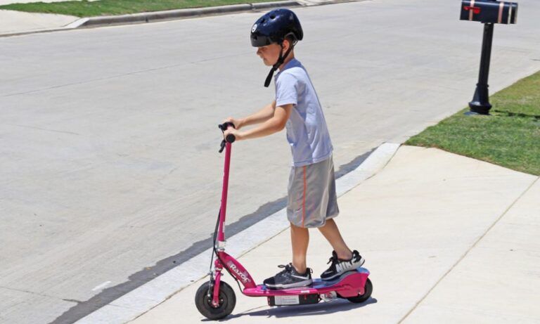boy riding a pink E100 electric scooter