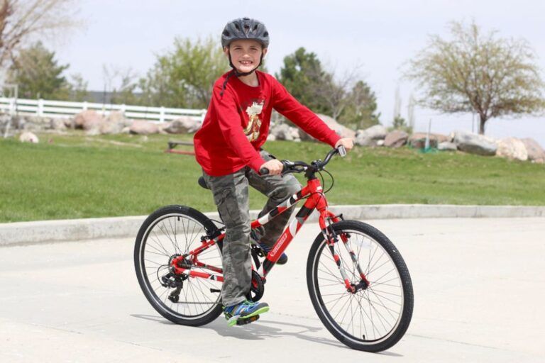 boy riding a red Guardian 24 inch bike