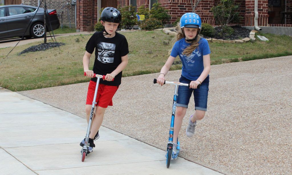 boy and girl riding the Razor Lux Razor A2 Kick Scooters