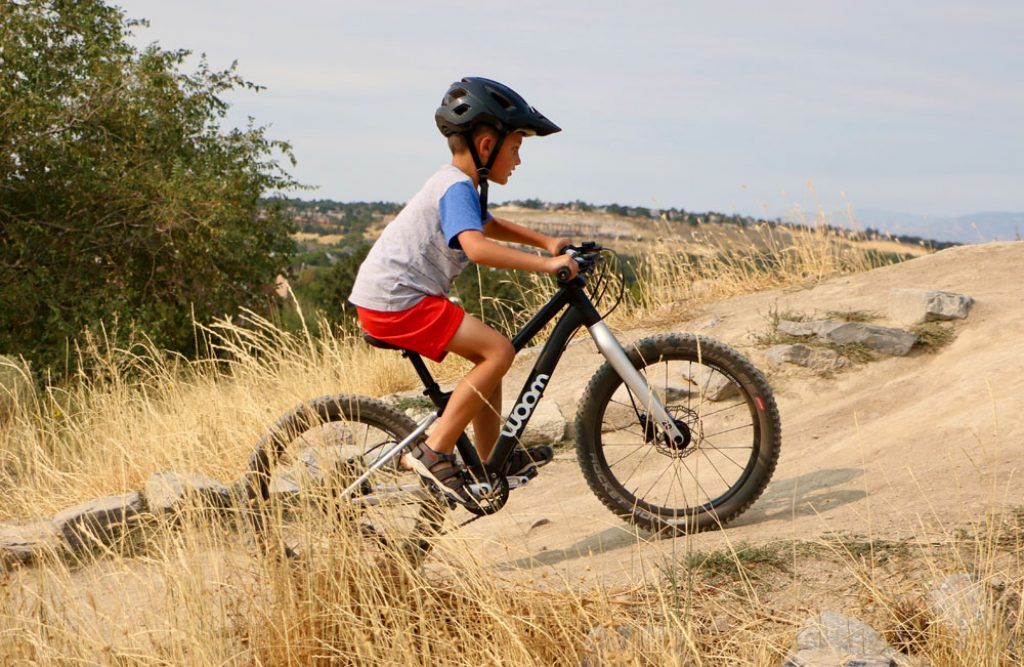 boy riding the woom OFF 4 20-inch bike at a bike park