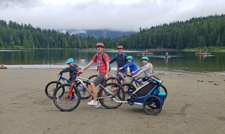 thule chariot cross trailer with family at lake