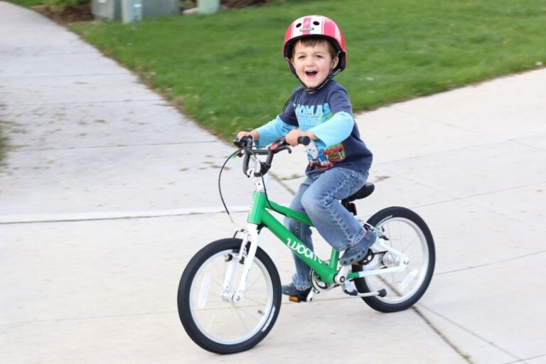 boy riding a green woom 3 balance bike