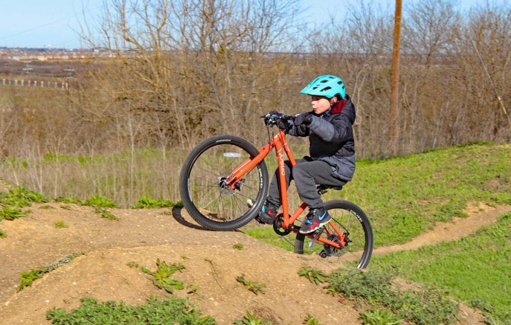 boy climbing his 24 inch Pello Reyes up a dirt hill