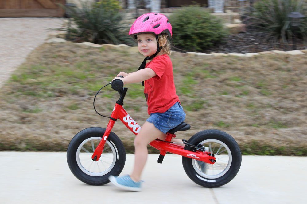 girl riding a red scoot balance bike