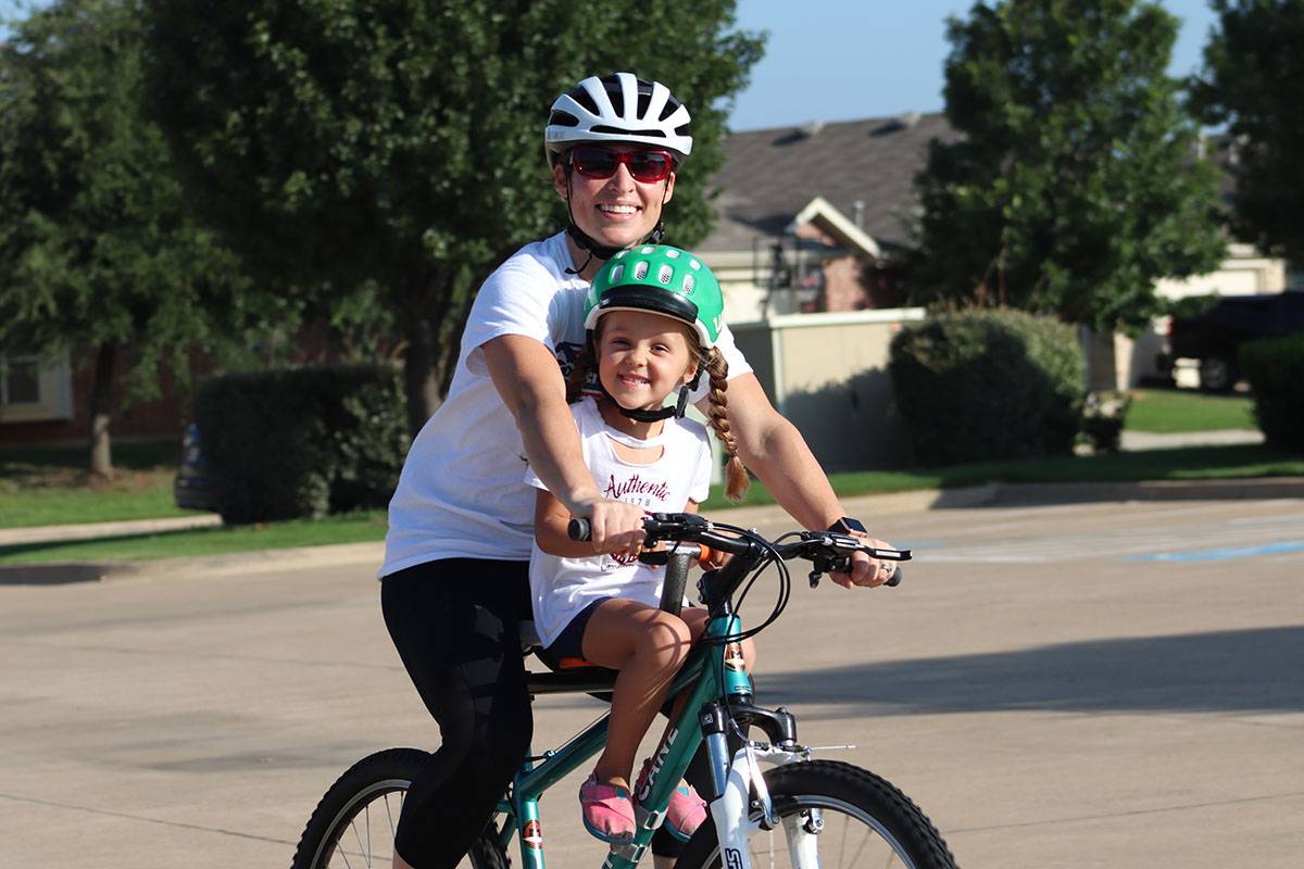 4 year old riding Tyke Toter child bike seat with mom