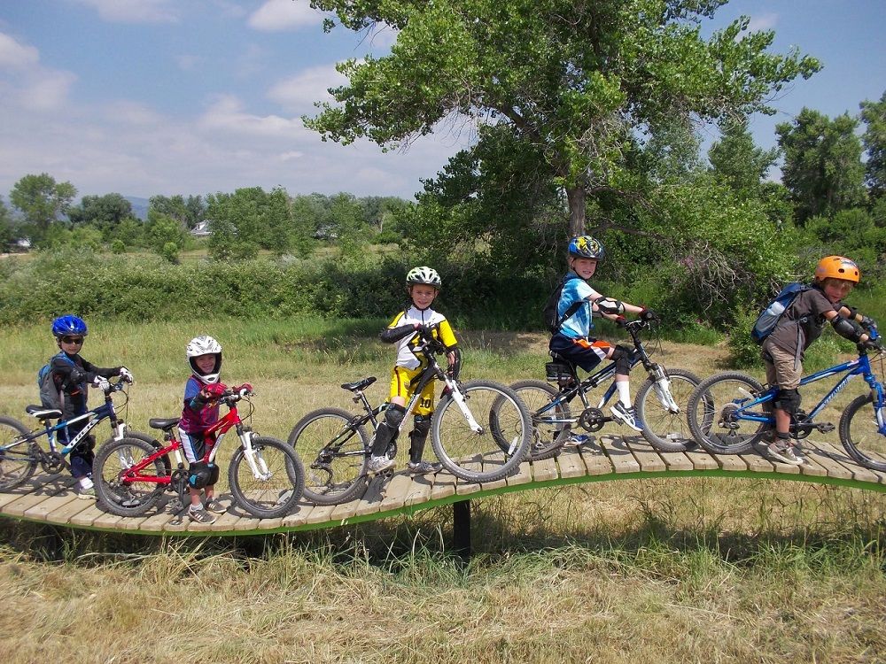 Valmont bike park in Boulder, CO with kids riding wood plank trail