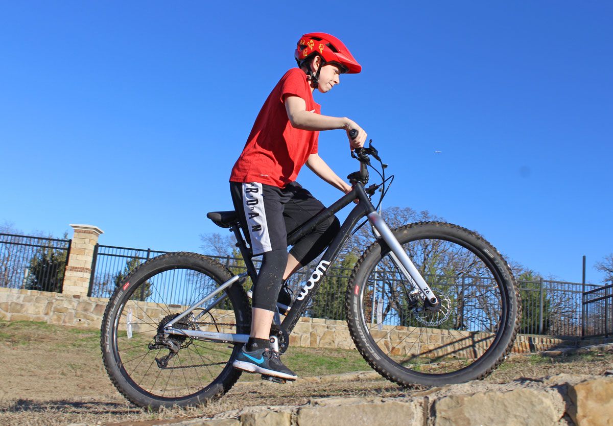 12 year old wearing Bell Sidetrack 2 Youth size bike helmet while riding woom OFF 6 mountain bike