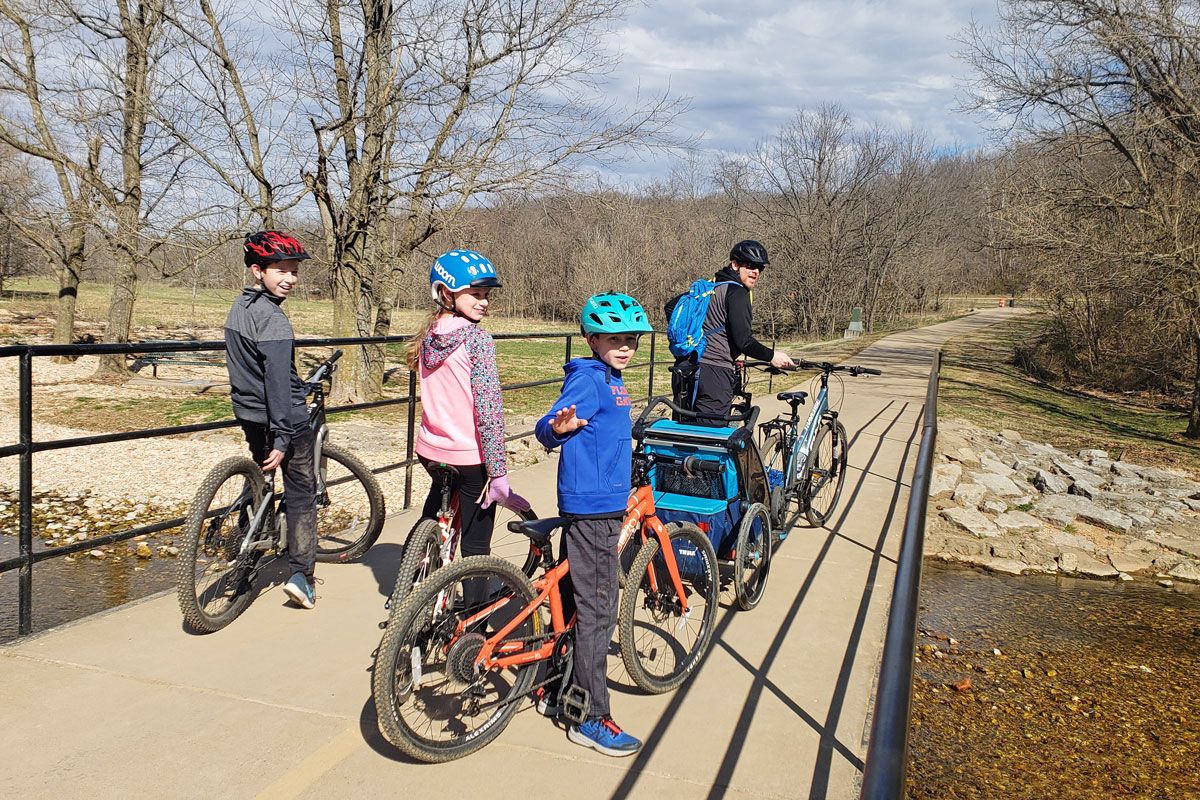Family with bikes on bridge at Slaughter Pen in Bentonville Arkansas