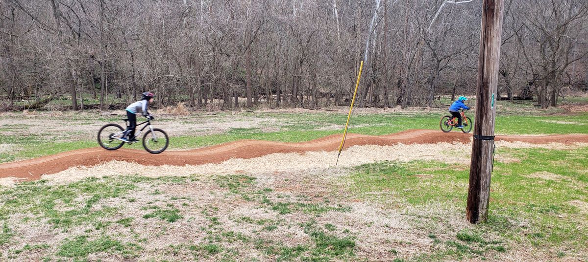 Two boys riding mountain bikes at Slaughter Pen flow trail in Bentonville Arkansas