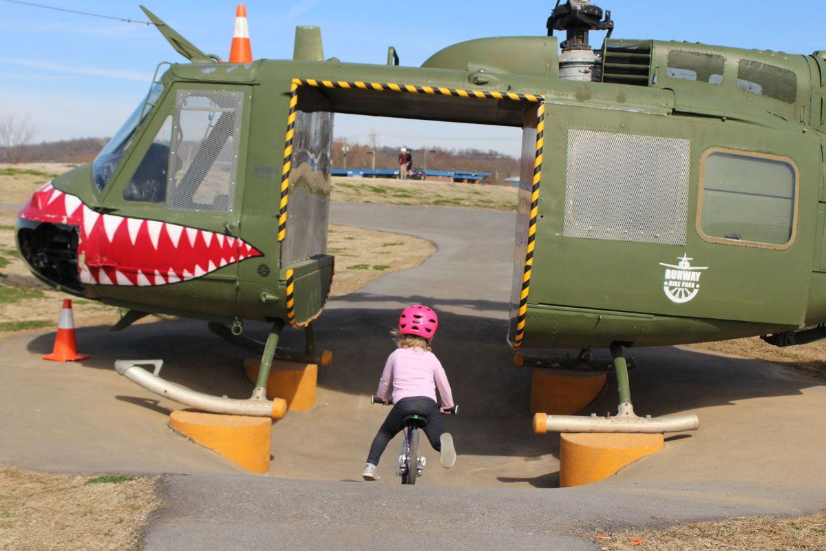 Toddler riding through the shark feature at Runway Bikepark in Springdale Arkansas
