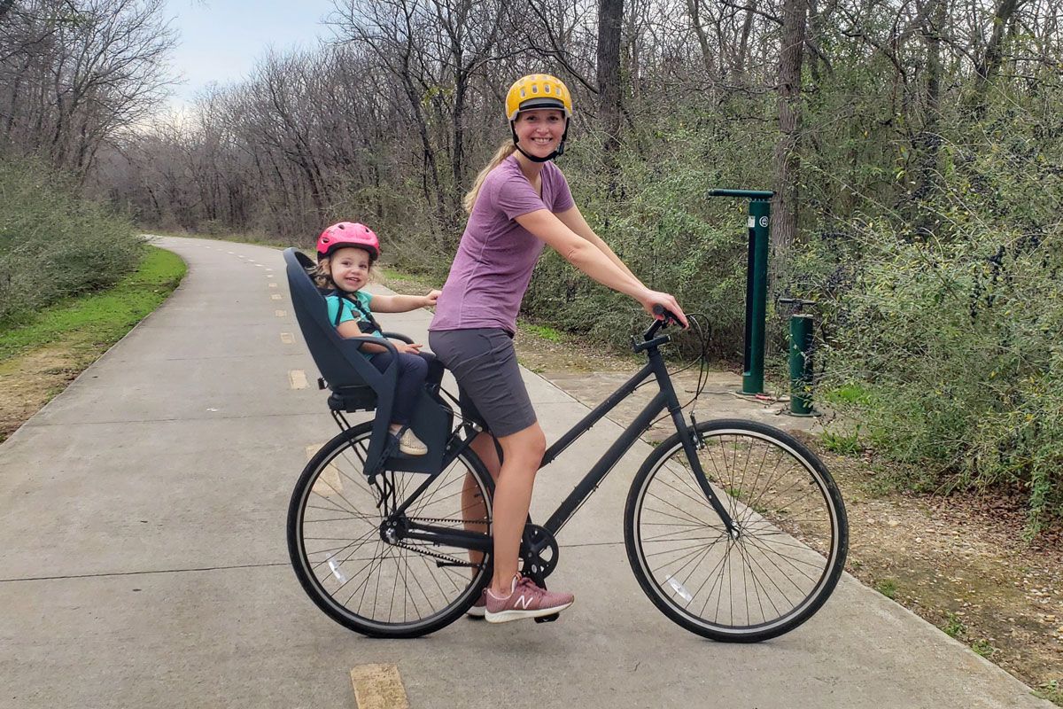 Mom riding with toddler in Burley Dash child bike seat on bike trail