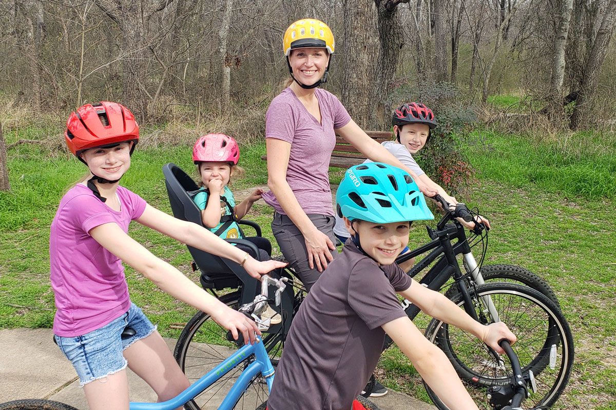 Family riding on bike trail. Toddler is in Burley Dash child bike seat.