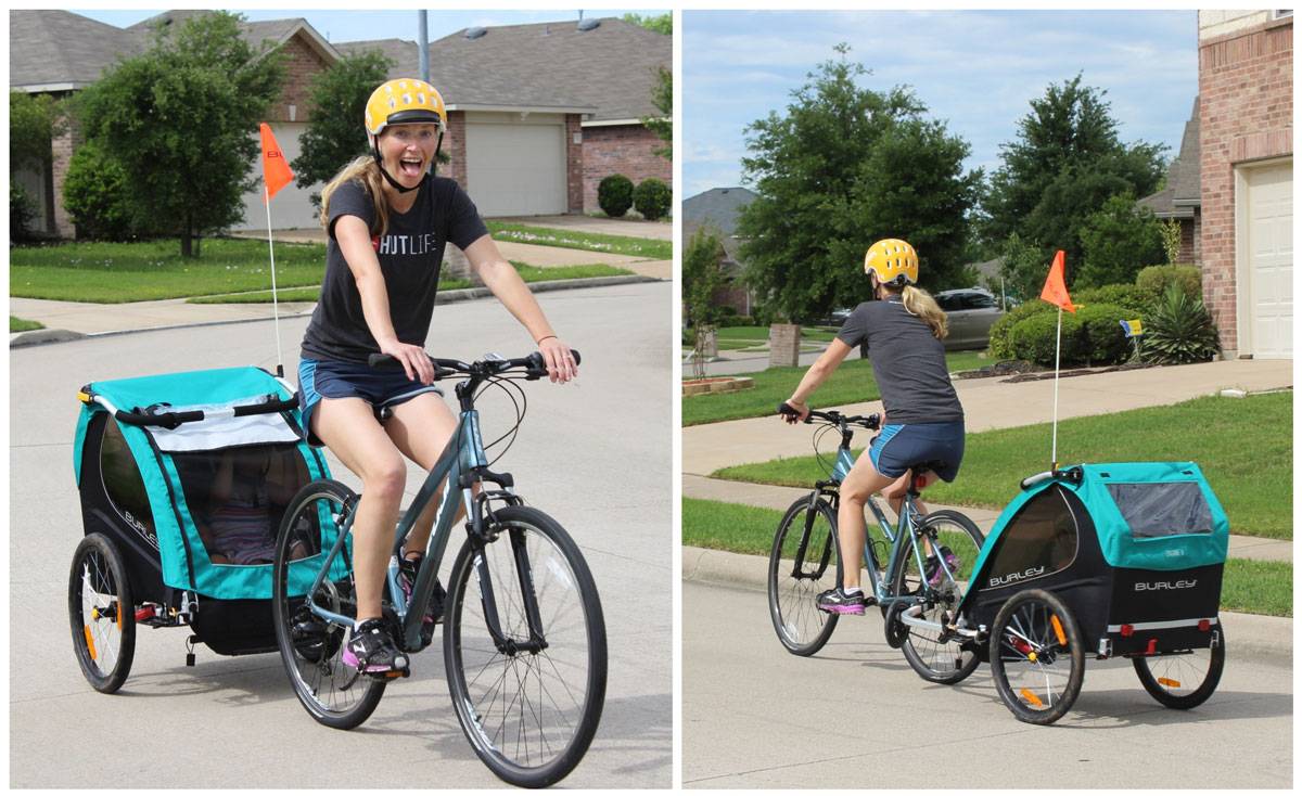 Mom pulling two toddlers in Burley Encore X bike trailer