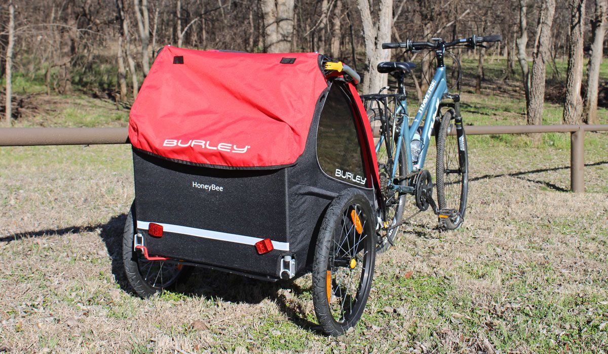 Burley Honey Bee bike trailer from rear. On large grass field.