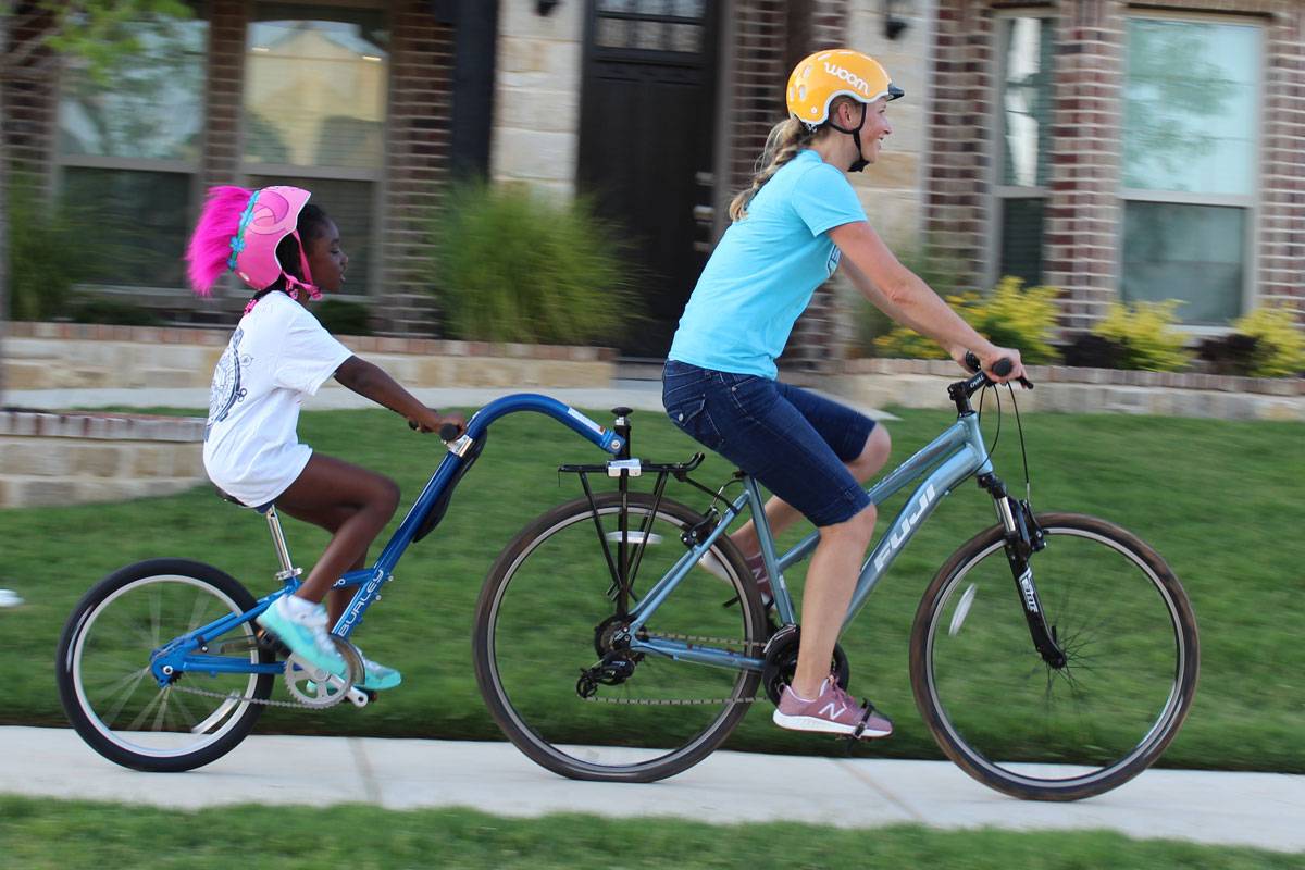 Mom pulling 8-year-old girl on the Burley Kazoo trailer cycle