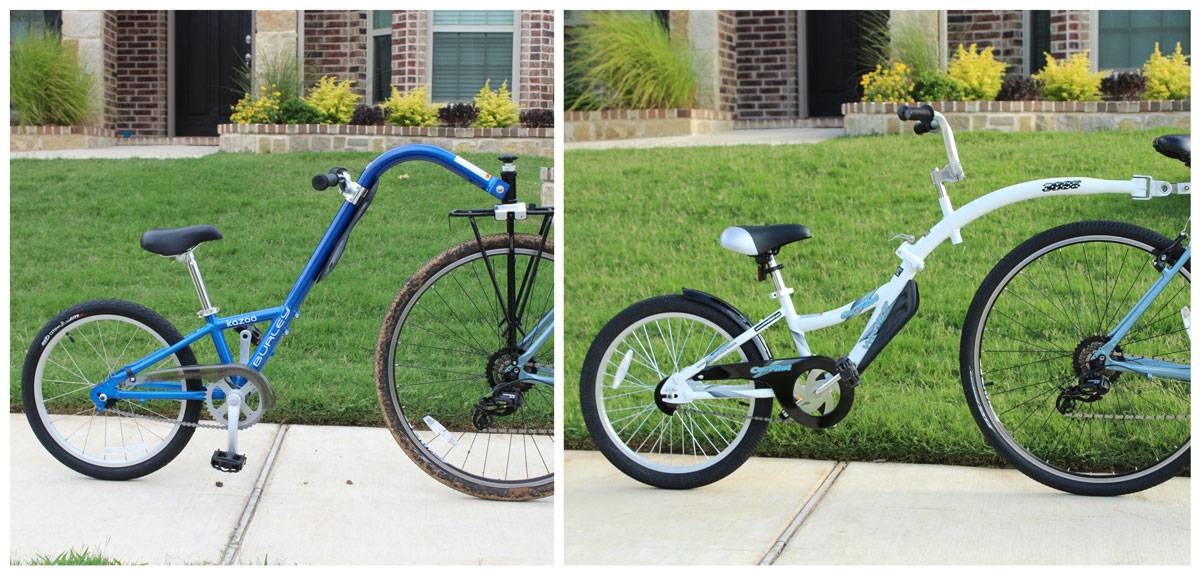 Side by side shot of Burley Kazoo and WeeRide CoPilot trailer cycles. Shows how the Kazoo's arm has much steeper arc to prevent it from coming into contact with the adult bike's rear wheel