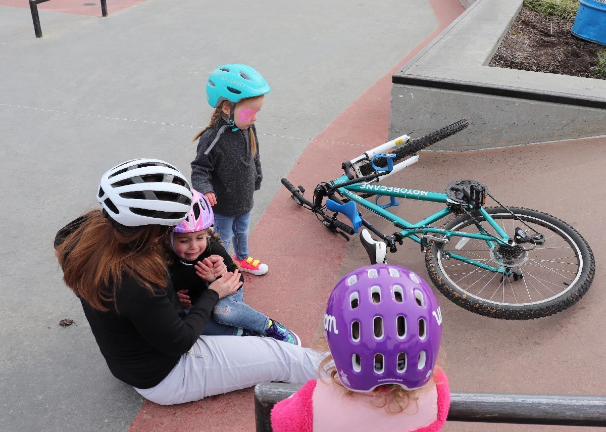 mom comforting her daughter after crashing on the Mac Ride child bike seat due to not tightening the handlebars all the way