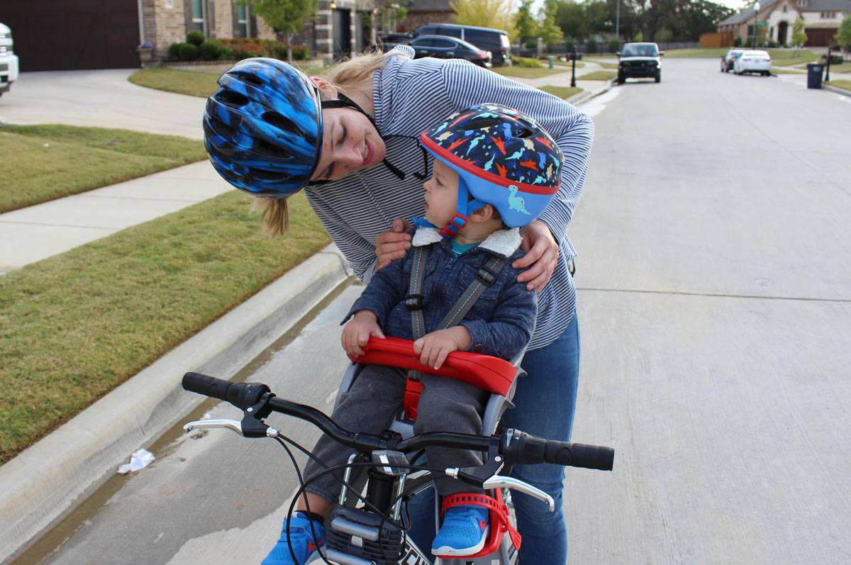 Mom smiling with 15-month-old boy in Peg Perego Orion child bike seat