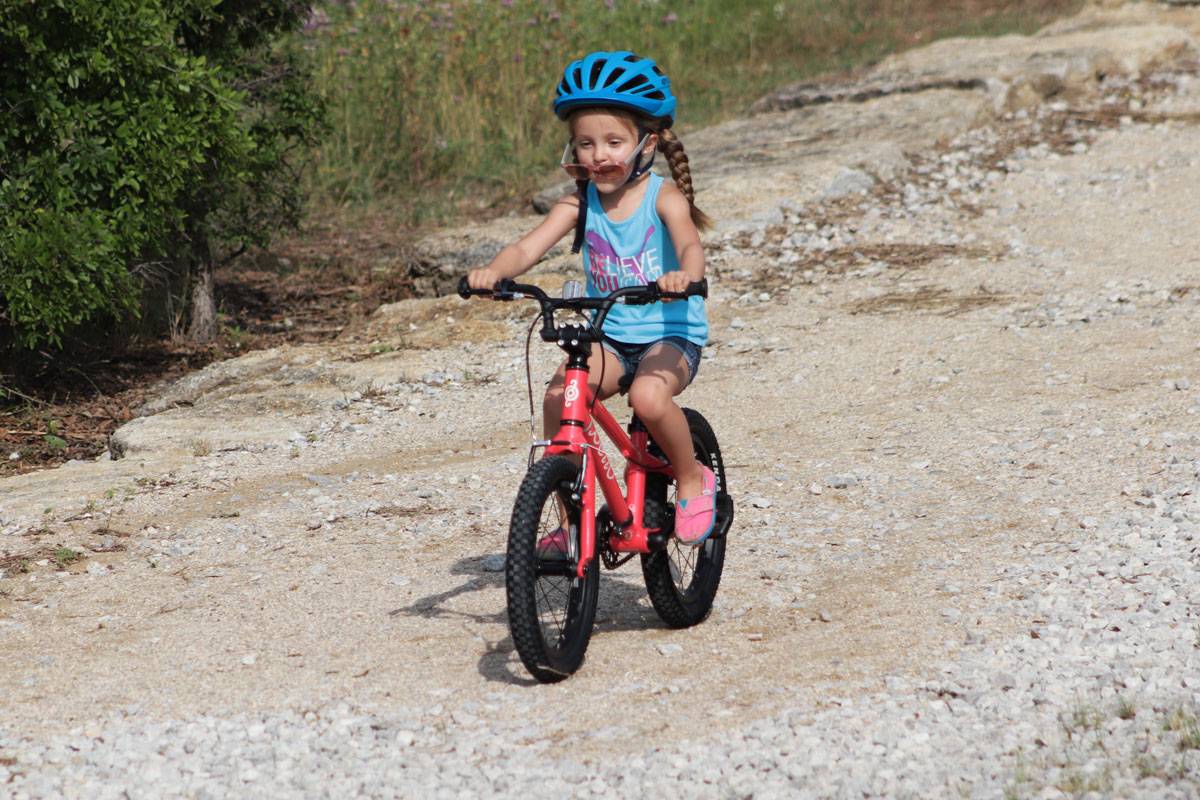 4 year old girl riding Pello Revo 16" bike on a gravel trail