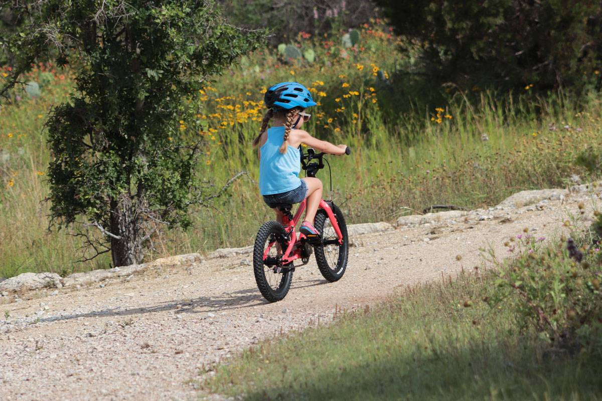 4 year old girl riding Pello Revo 16" bike on a dirt trail