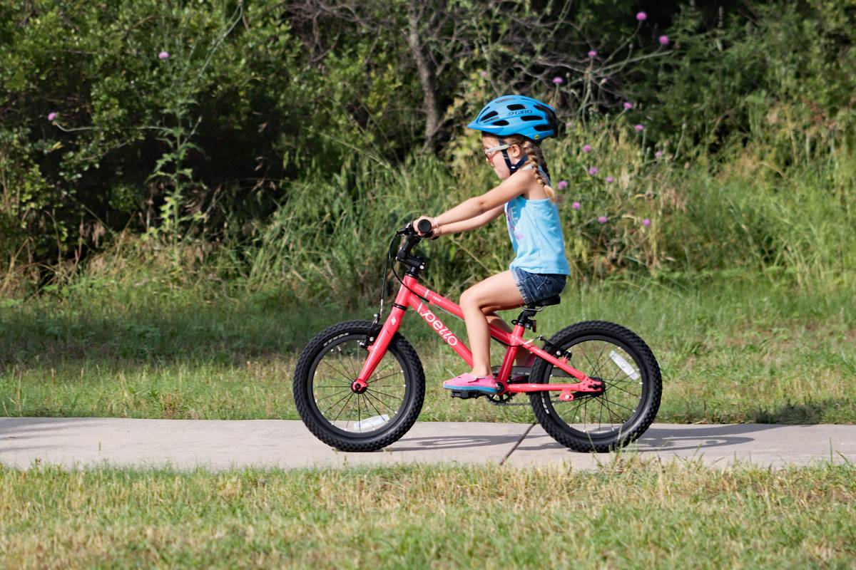 4 year old girl riding Pello Revo 16" bike on a paved trail