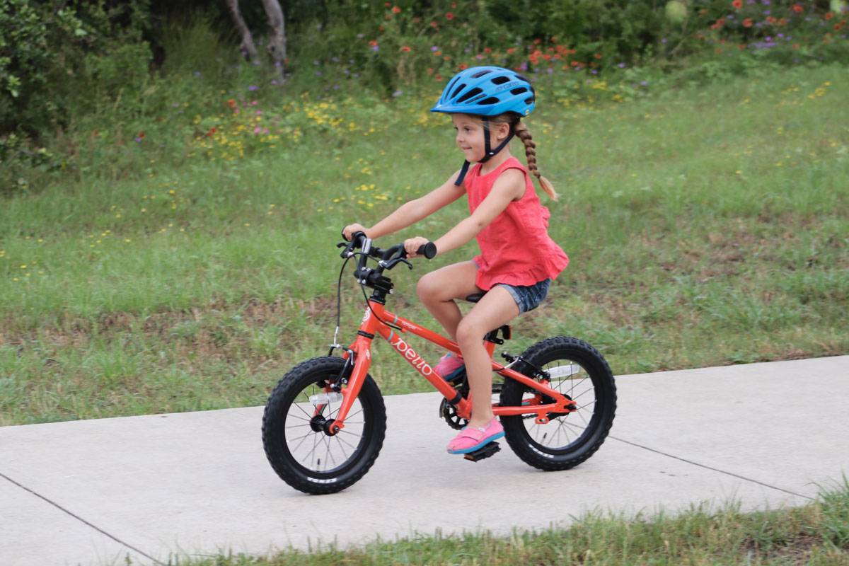 young girl riding the Pello Romper 14 inch bikes