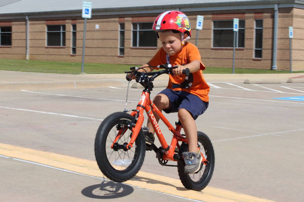 4 year old boy riding up a jump on the Pello Romper 14" kid's bike