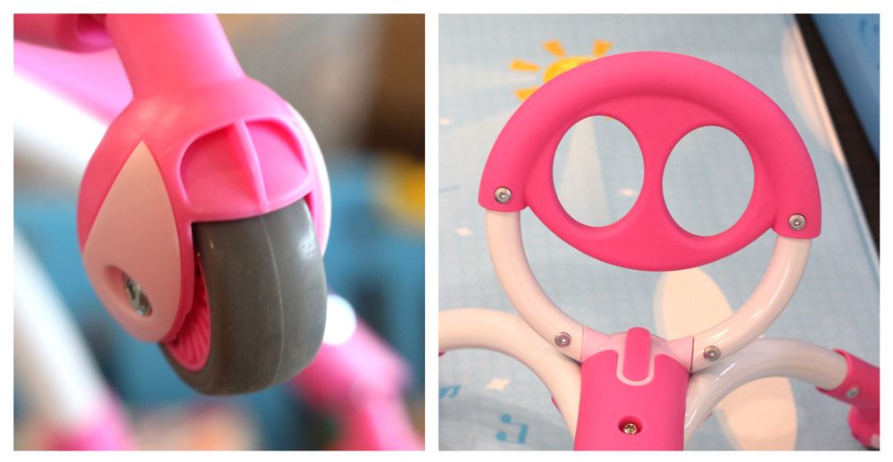 Upclose shot of rubber caster wheel on Pewi, and the round "handlebar" that looks like a smiling face.