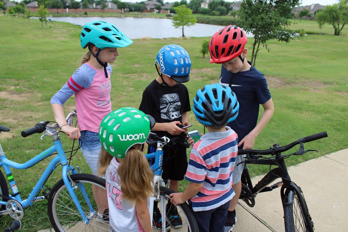 Group of kids playing Pokemon Go by Bike in the park
