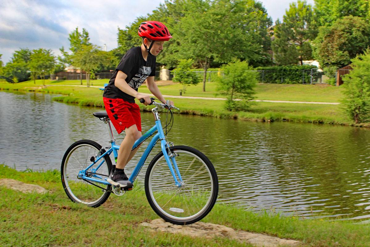 boy riding Priority Bicycles Start 24 inch bike over a rock