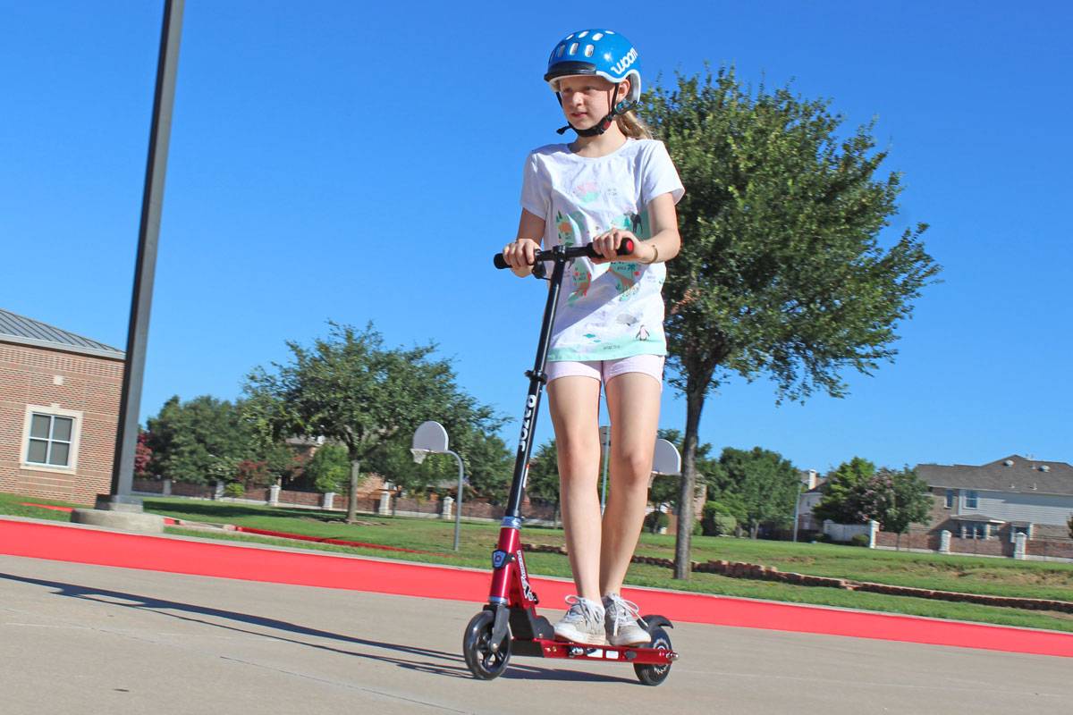 10 year old girl riding Razor Power A2 electric scooter on school playground
