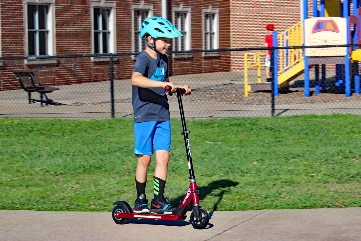 8 year old boy riding Razor Power A2 electric scooter on school playground