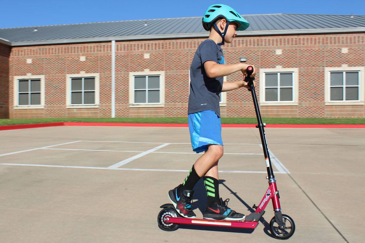 8 year old boy riding Razor Power A2 electric scooter on school playground