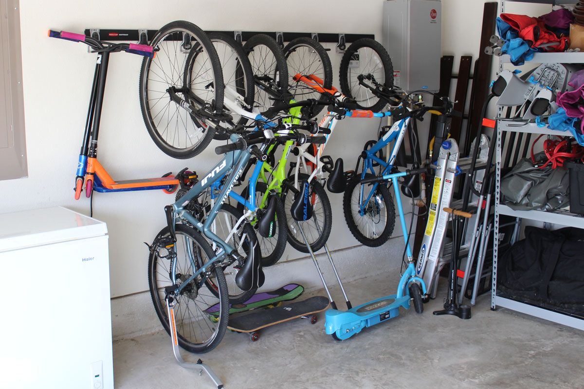 Rubbermaid FastTrack storage system in garage with scooters and bikes hanging from it