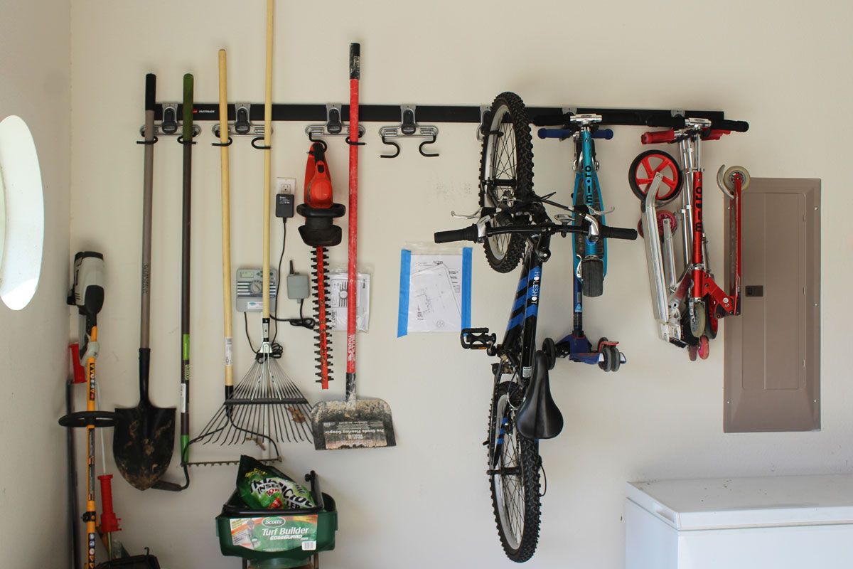 Rubbermaid FastTrack storage system in garage with garden tools and bikes hanging from it