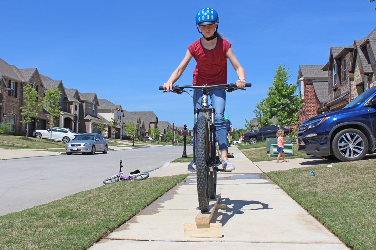 11 year old riding wooden skinny feature on Marin Wildcat Trail bike
