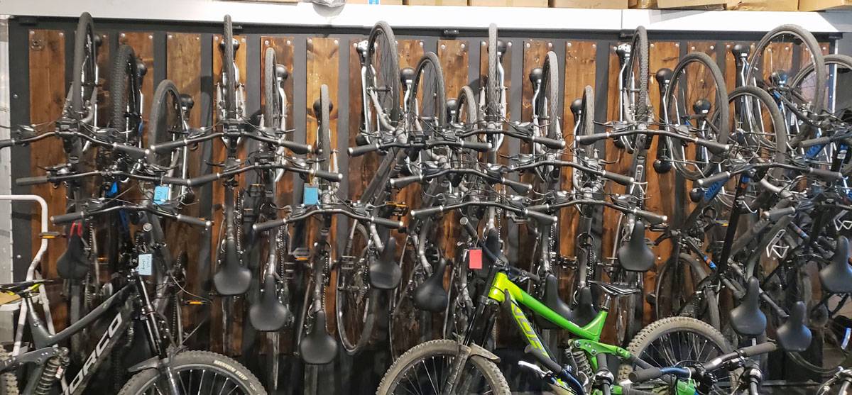 Wall of bike shop in Whistler, holding dozens of bikes in Steadyracks.