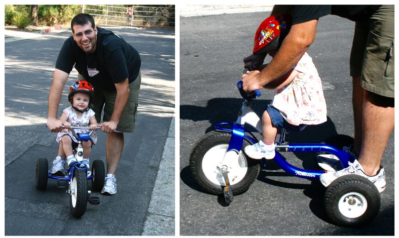 Dad trying to help his daughter ride tricycle that is clearly too large for her.