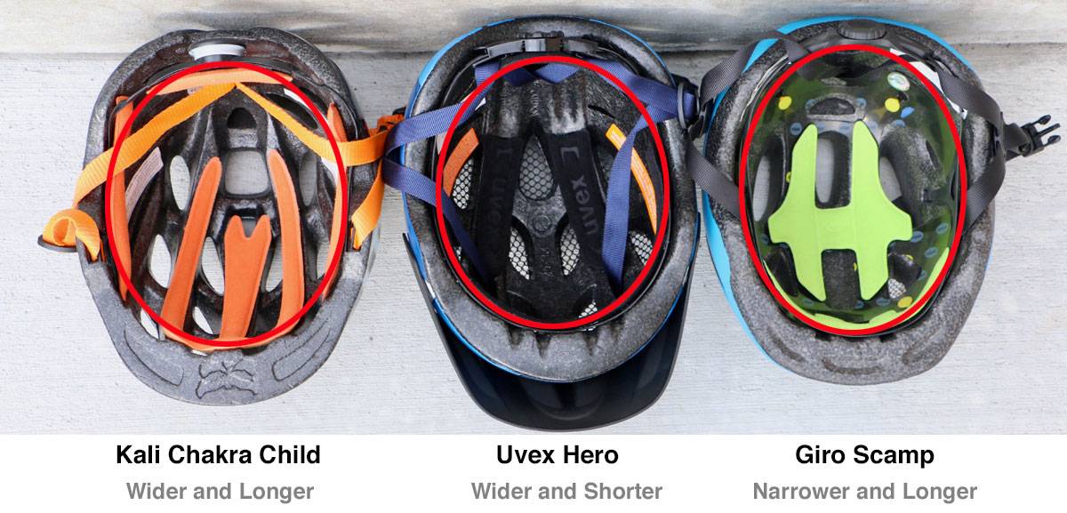 Three helmets side by side, showing difference in shape of inner cage. Kali Chakra child is wider and longer. Uvex Hero is wider and shorter. Giro Scamp is narrower and longer