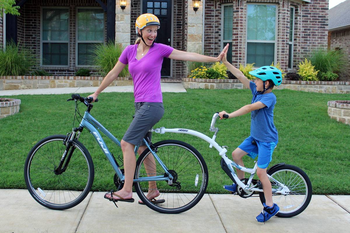 Mom and son high fiving on weeride copilot bike