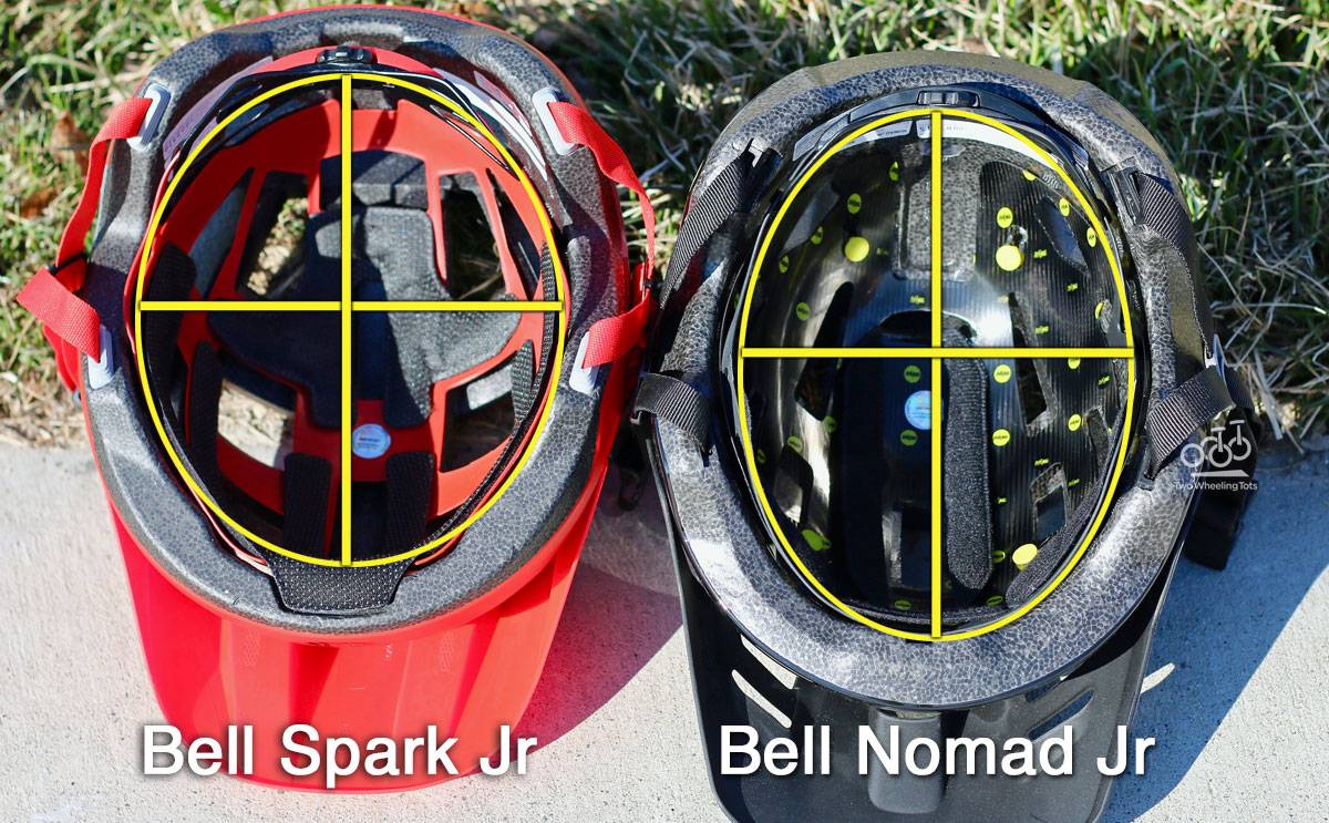 Side by side shot of Bell Spark Jr and Bell Nomad Jr showing underside. The interior of the Bell Spark is much wider and rounder.