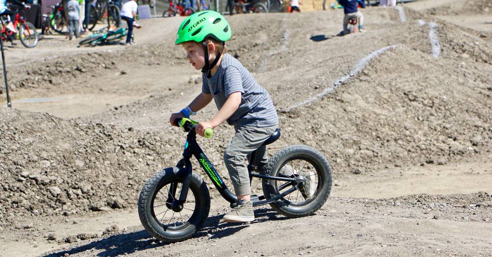 Preschooler riding the 2019 Specialized Hotwalk balance bike on dirt pump track