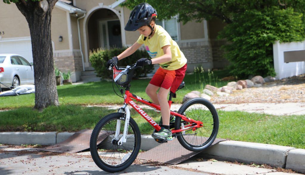 boy riding on a red schwinn koen 20 inch smartstart bike