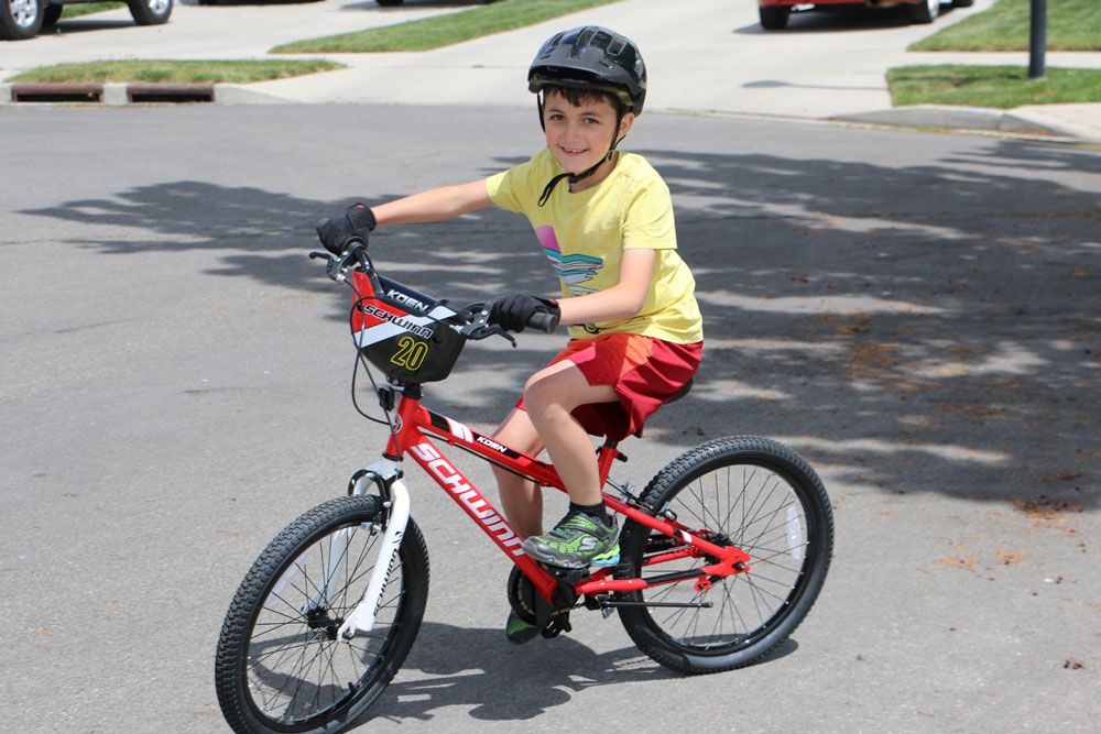 8 year old boy riding Schwinn Koen 20 inch kids bike in the street