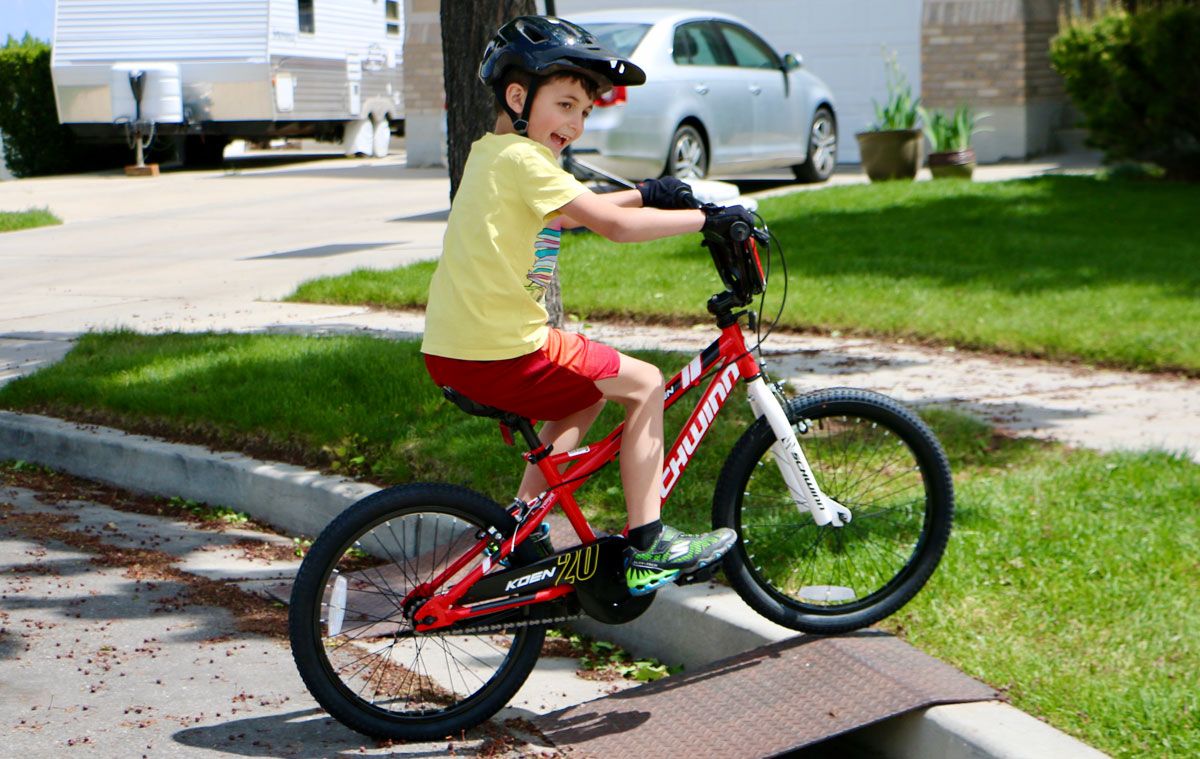 8 year old boy riding up ramp on Schwinn Koen 20 inch boys bike