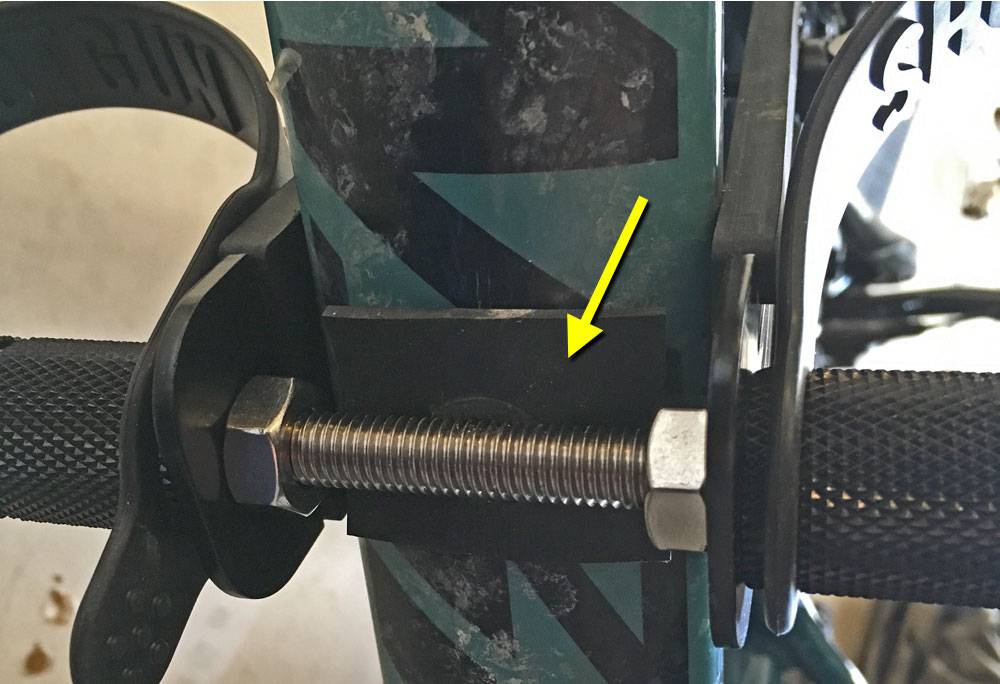 Underside of mountain bike frame with piece of rubber under screw when mountain the shotgun seat